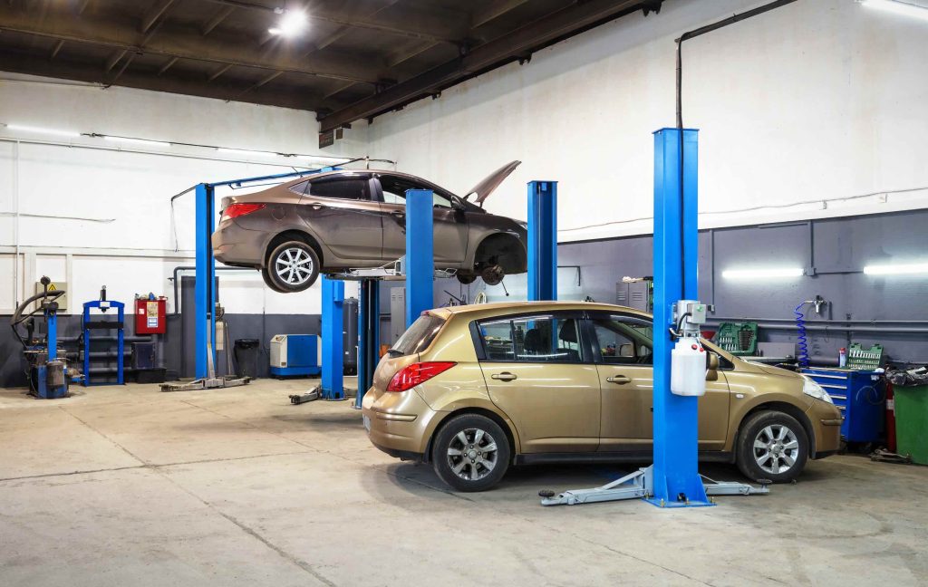 Car on lift in mechanic shop or garage, interior of auto repair workshop, vehicles inside maintenance. Concept of workplace and business - small service station - MOT, Servicing & Repairs | Huntingdon