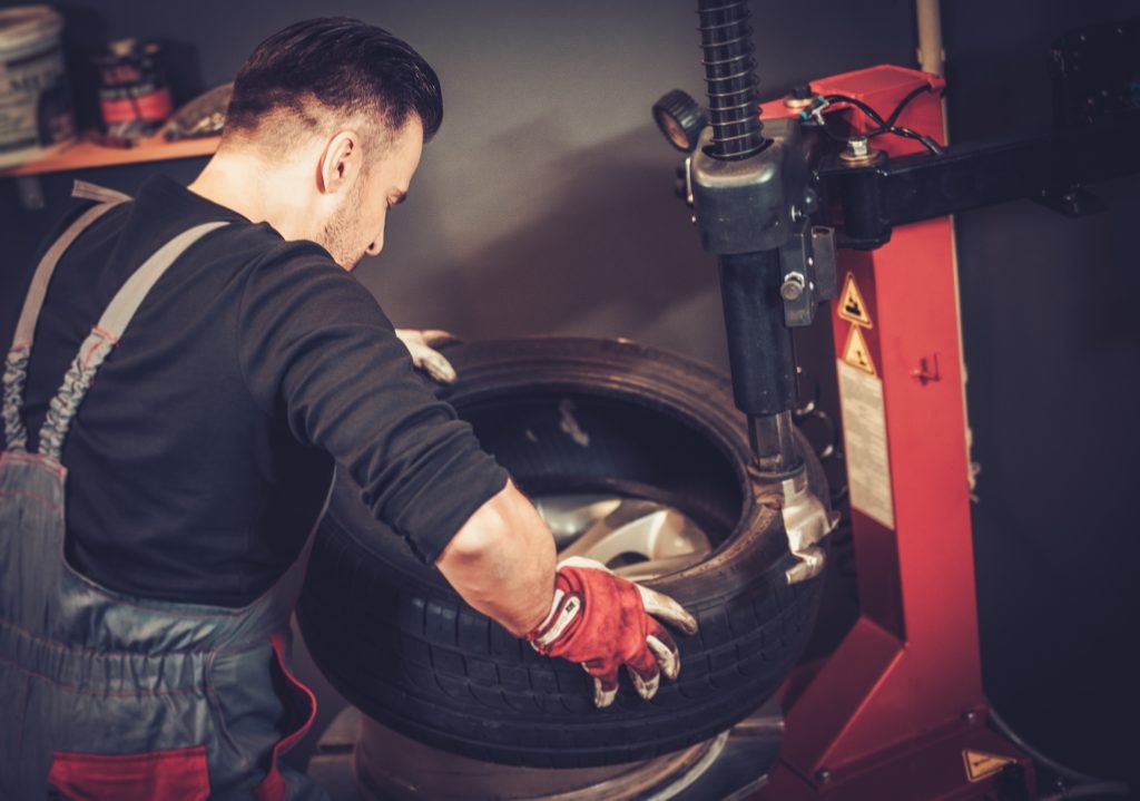 Professional car mechanic replace tire on wheel in auto repair service - Tyres & Tyre Fitting Huntingdon